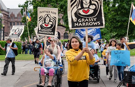 leden van de Grassy Narrows-gemeenschap uit Canada demonstreren op straat met pancartes