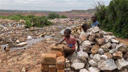 Spelende kinderen aan de rand van de open groeve van de koper- en kobaltmijn van Kolwezi, in de buurt van Gécamines Kolwezi, DRC